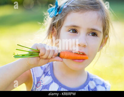 Little girl (4-5) eating carrot Banque D'Images