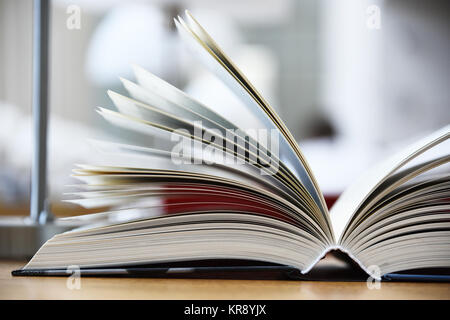 Livre relié allongé sur la table dans une bibliothèque Banque D'Images