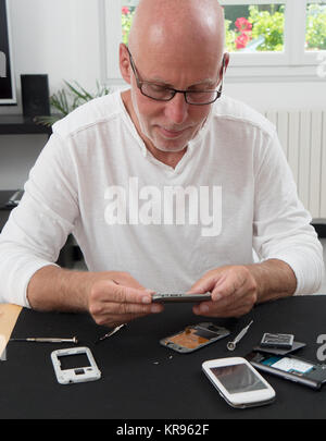 Homme réparé un smartphone Banque D'Images