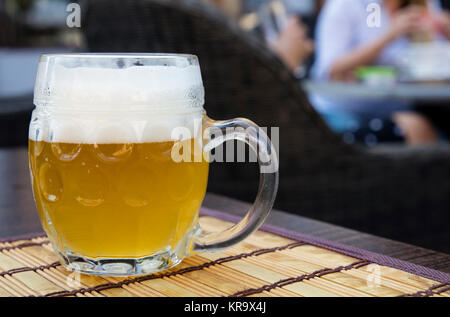 Tasse en verre de bière weizen non filtrée sur table Banque D'Images