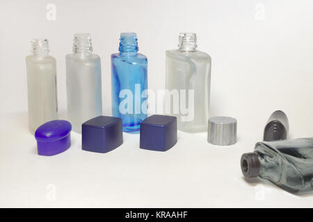 Transparent vide bouteilles de lotions après-rasage avec ouvrir les bouchons dans une rangée Banque D'Images
