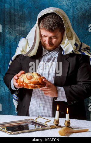 Un homme se casse de samedi du pain challah Maison festive à Chabbat Banque D'Images