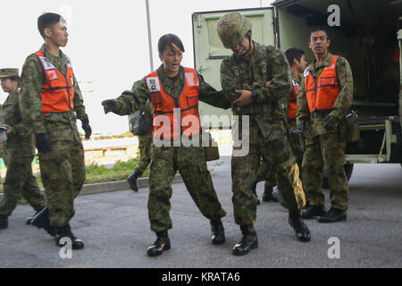 Le Japon des soldats de la Force d'auto-défense au sol avec service médical, du personnel au sol de l'Office, l'Armée de l'Ouest, assister à une victime simulée lors d'un grand nombre de victimes, le 12 décembre 2017 scénario au Camp, Naha, Okinawa, Japon. Le personnel médical de 3ème Bataillon Médical, 3e Groupe Logistique Maritime ; U.S. Naval Hospital ; Okinawa et 18e Groupe médical, 18e Escadron de soutien de l'aile ont été invités au camp au cours de la Naha américain et japonais de l'échange d'experts médicaux de la formation pour en savoir plus sur chaque service de formation médicale, tactiques et procédures. (U.S. Marine Corps Banque D'Images