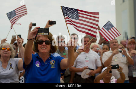 Employés de la NASA et les entrepreneurs agitent des drapeaux et faire des photos comme la navette spatiale Atlantis (STS-135) descende vers l'orbiter processing facility (OPF) à un événement d'arrêt, les roues Jeudi, 21 juillet 2011, à la NASA's Kennedy Space Center à Cape Canaveral, Floride Atlantis retourne à Kennedy tôt jeudi à la suite d'une mission de 13 jours vers la Station spatiale internationale (ISS) et marquant la fin de la période de 30 ans du Programme de la navette spatiale. Dans l'ensemble, l'Atlantide a passé 307 jours dans l'espace et parcouru près de 126 millions de kilomètres au cours de ses vols 33. Atlantis, la quatrième orbiter construit, a lancé sa première mission le 3 octobre Banque D'Images