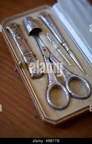 Kit de couture ancienne à broderies argentées avec ciseaux, thimble, threader, awl et trousse à aiguilles - mise au point minimale Banque D'Images