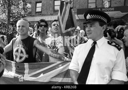 Les partisans du Front National afficher un drapeau de l'Union européenne tandis que la police de surveiller la marche par des sympathisants républicains irlandais à Londres. Banque D'Images