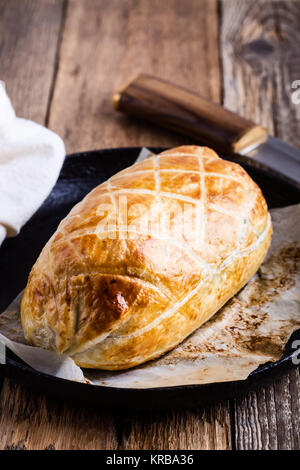 Boeuf Wellington en cast iron skillet, steak classique plat sur table rustique Banque D'Images