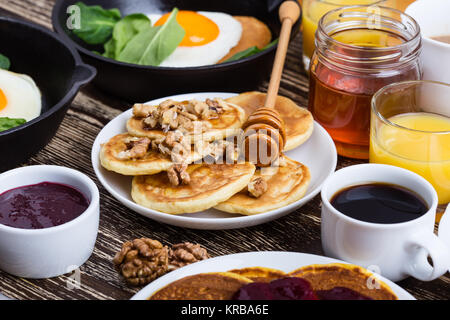 Valentine's day breakfast ou un brunch. Forme de coeur fait maison et d'œufs au plat en fonte poêle à crêpes aux épinards, de crêpes au miel et noix, Banque D'Images