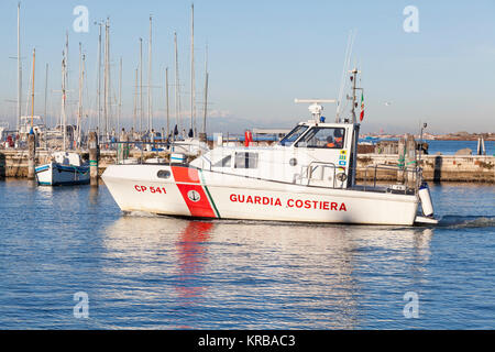 Un Italien Guardia Costiera ou bateau de la garde côtière patrouillant dans le port de Chioggia, Venise, Italie dans la lumière du soir Banque D'Images