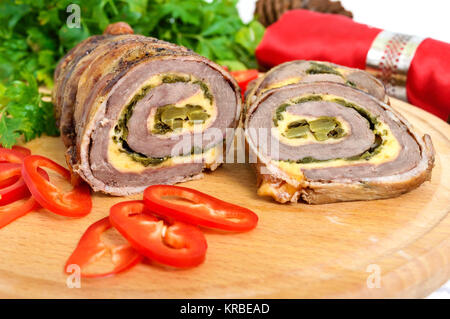 Viande (roll ) avec du fromage, épinards, concombres enrobé de bacon avec de la sauce tomate sur un fond de bois blanc. Maison de vacances menu. Banque D'Images