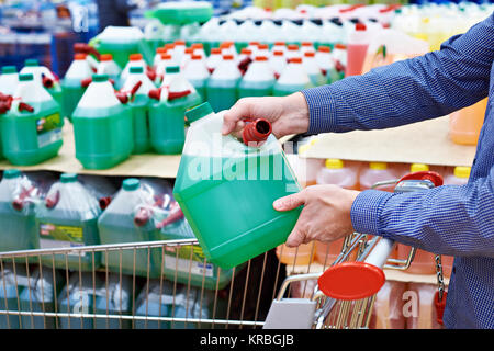L'homme achète du liquide lave-glace dans le supermarché Banque D'Images