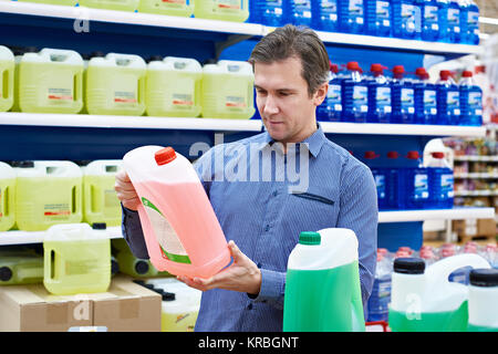 L'homme achète du liquide lave-glace dans le supermarché Banque D'Images