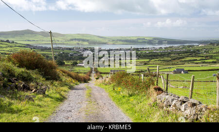 Une piste de pierre, anciennement la route principale à l'Conor Pass, grimpe Conor Hill de la ville de Dingle, avec derrière le port de Dingle, en Irlande, le comté de Kerry. Banque D'Images