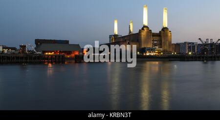 Londres, Angleterre, Royaume-Uni - juin 8, 2013 : l'emblématique cheminées de la Battersea Power Station à l'abandon à allumée dans le crépuscule sur la Tamise dans l'ouest de Lon Banque D'Images