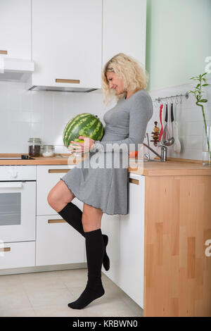 Fille blonde avec les cheveux bouclés avec watermelon Banque D'Images