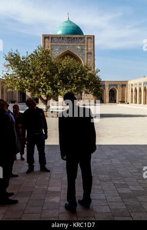 Visiteurs ouzbeks dans la cour intérieure de la mosquée Kalyan, Boukhara, Ouzbékistan Banque D'Images