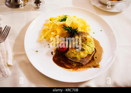 Grillades de porc et sauce spaghetti sauce aux champignons et à la crème sur une plaque en céramique sert le dîner au restaurant à Pfunds village de Tyrol, Autriche Banque D'Images