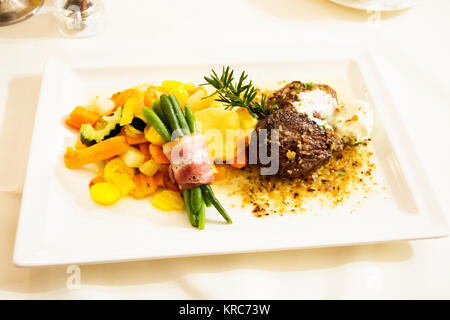 Steak de bœuf et sauce sauce avec le mélange de légumes frits et rouleau de jambon Haricots longs sur plaque en céramique sert le dîner au restaurant à Pfunds village de Tyrol, Banque D'Images