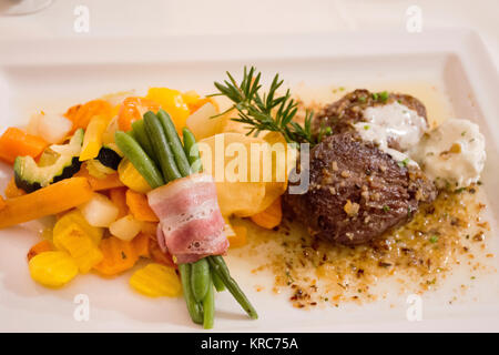 Steak de bœuf et sauce sauce avec le mélange de légumes frits et rouleau de jambon Haricots longs sur plaque en céramique sert le dîner au restaurant à Pfunds village de Tyrol, Banque D'Images