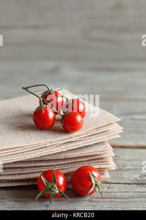 Matières les feuilles de lasagne et tomates cerises Banque D'Images