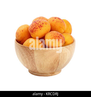 Abricots frais mûrs dans bol en bois sur fond blanc Banque D'Images