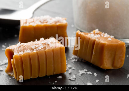 Fabriqué à la main en morceaux de toffee caramel au sel de cuisine sur l'arrière-plan de la plaque en pierre