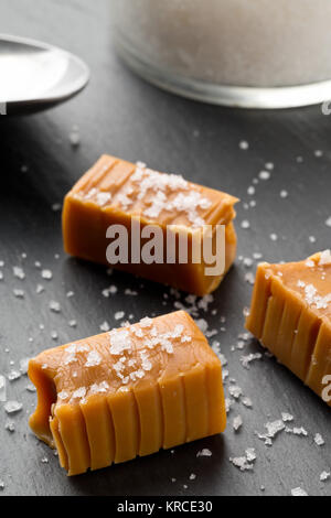 Fabriqué à la main en morceaux de toffee caramel au sel de cuisine sur l'arrière-plan de la plaque en pierre