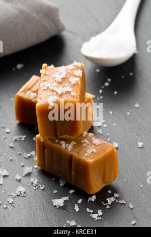 Fabriqué à la main en morceaux de toffee caramel au sel de cuisine sur l'arrière-plan de la plaque en pierre