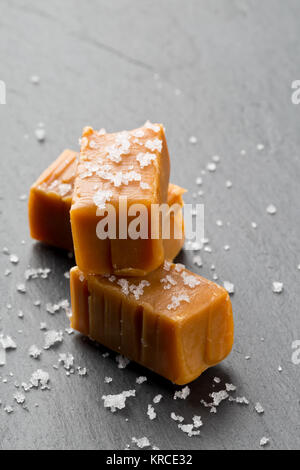 Fabriqué à la main en morceaux de toffee caramel au sel de cuisine sur l'arrière-plan de la plaque en pierre