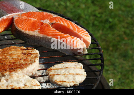 Burgers de poulet ou de dindon et de saumon sur le gril poisson Banque D'Images