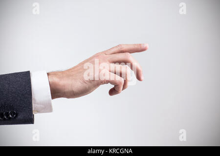 Businessman's main pointant dans l'air. Sur fond gris. Banque D'Images