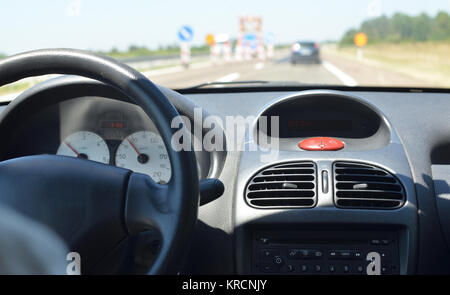 Conduire une voiture sur une route avec des travaux et avec d'autres véhicules floue devant lui Banque D'Images