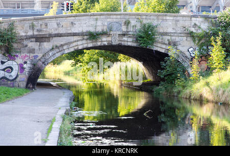 La route traverse l'Irlande Ballybough Royal Canal sur un pont en arc de pierre dans le quartier North Strand de Dublin. Banque D'Images