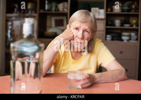 Woman with hand on joue en buvant de l'alcool Banque D'Images