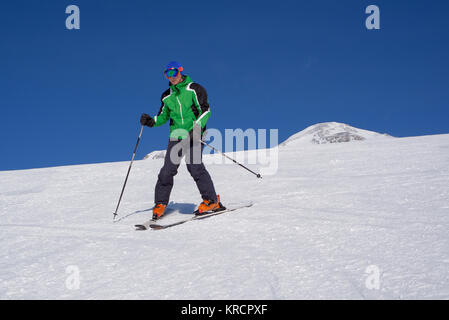 Skier dans la pente enneigée Banque D'Images