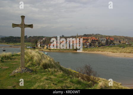 Vue du village d'Alnmouth à l'embouchure de la rivière ALN, Alnwick, Northumberland. Une grande croix en bois se dresse au premier plan, marquant le site d'une ancienne église. Banque D'Images