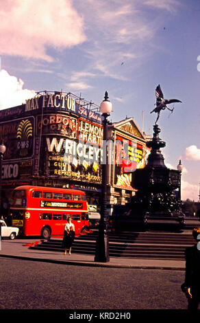 Vue de Piccadilly Circus, Londres, en journée, avec un bus à impériale rouge, publicité pour Max Factor, Wrigleys, etc., et la statue d'Eros. Banque D'Images