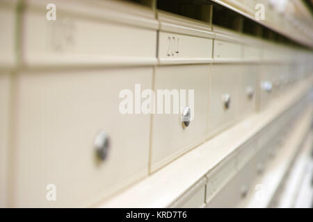 Close-up d'une rangée de boîtes aux lettres en milieu urbain, de couleur crème, avec des chiffres, lettre et les serrures. Dans les boîtes aux lettres appartenant à un immeuble d'appartements à Sydne Banque D'Images