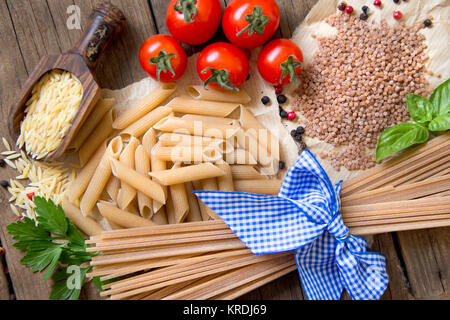 Les pâtes, les tomates, le basilic et le persil sur fond de bois Banque D'Images