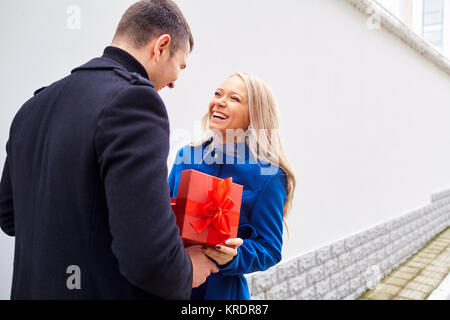 Un homme donne une boîte avec un cadeau à une femme. Banque D'Images