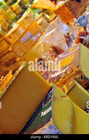 Une variété de disque français et suisses et les fromages en vente sur un étal à Borough Market à Londres. Charcuterie et fromages produits. Banque D'Images