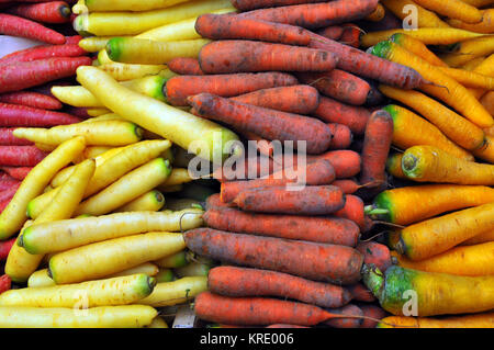 Une variété de rouge, jaune et orange carottes colorés en vente sur un étal de fruits et légumes frais à Borough Market, Southwark, Londres. 5 Un jour wonky Banque D'Images