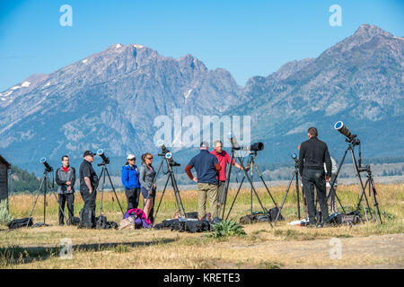 Un groupe de photographes se tiennent près de leurs équipements de l'appareil photo tout en parlant entre eux en face de Teton Mountain Range, Grand Tetons National P Banque D'Images