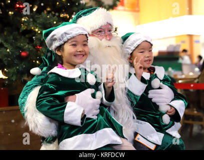 Tokyo, Japon. Déc 19, 2017. Le Père Noël vert sourit avec peu d'enfants en costumes vert alors qu'il visite le parc à thème carrière Kidzania Tokyo le mardi 19 décembre 2017. Le Père Noël vert du Danemark est maintenant au Japon en tant qu'ambassadeur de bonne volonté de l'écologie. Credit : Yoshio Tsunoda/AFLO/Alamy Live News Banque D'Images