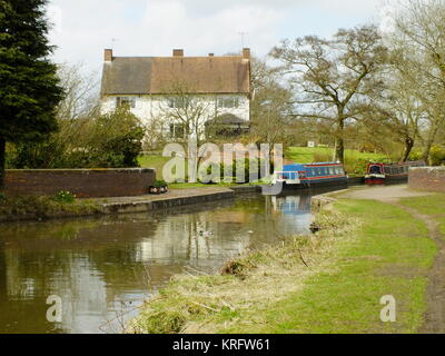 Vue sur une maison et des péniches sur un petit aqueduc juste au nord du pont autoroutier M42 sur le canal Worcester Birmingham. Banque D'Images