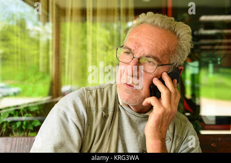 Tout juste d'entendre la mauvaise nouvelle - old man using mobile phone Banque D'Images