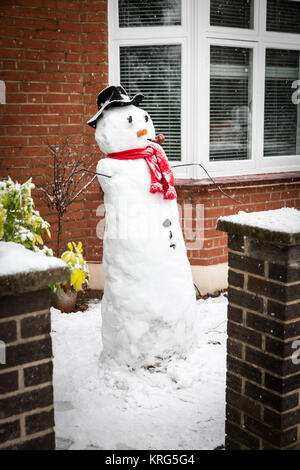 Un bonhomme de neige dans le jardin de devant d'une maison de la banlieue de Londres. Banque D'Images