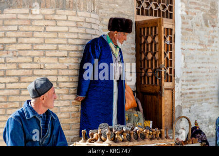 Un vieil homme ouzbèkes vend des souvenirs d'un décrochage dans le marché, Boukhara, Ouzbékistan Banque D'Images