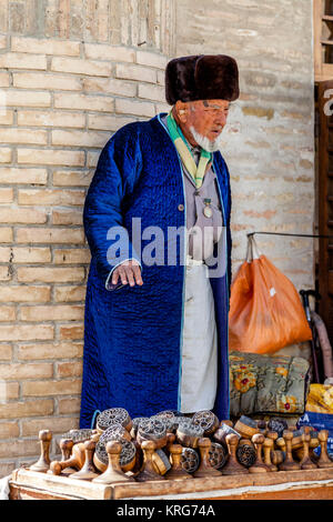 Un vieil homme ouzbèkes vend des souvenirs d'un décrochage dans le marché, Boukhara, Ouzbékistan Banque D'Images