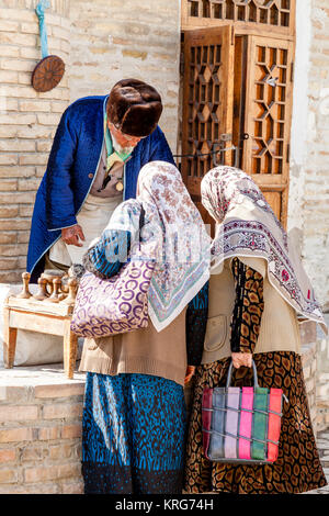 Un vieil homme ouzbèkes vend des souvenirs d'un décrochage dans le marché, Boukhara, Ouzbékistan Banque D'Images